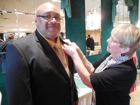 Barb McConihe of the LSHOF Committee pins a boutonniere on inductee Gary Huff